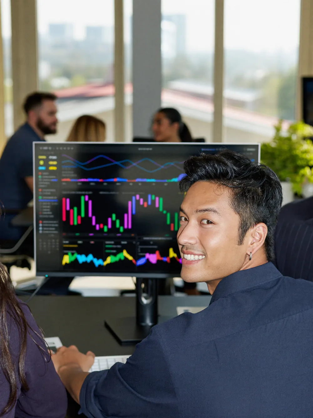 Ragazzo in un’agenzia di marketing davanti a un monitor con i grafici