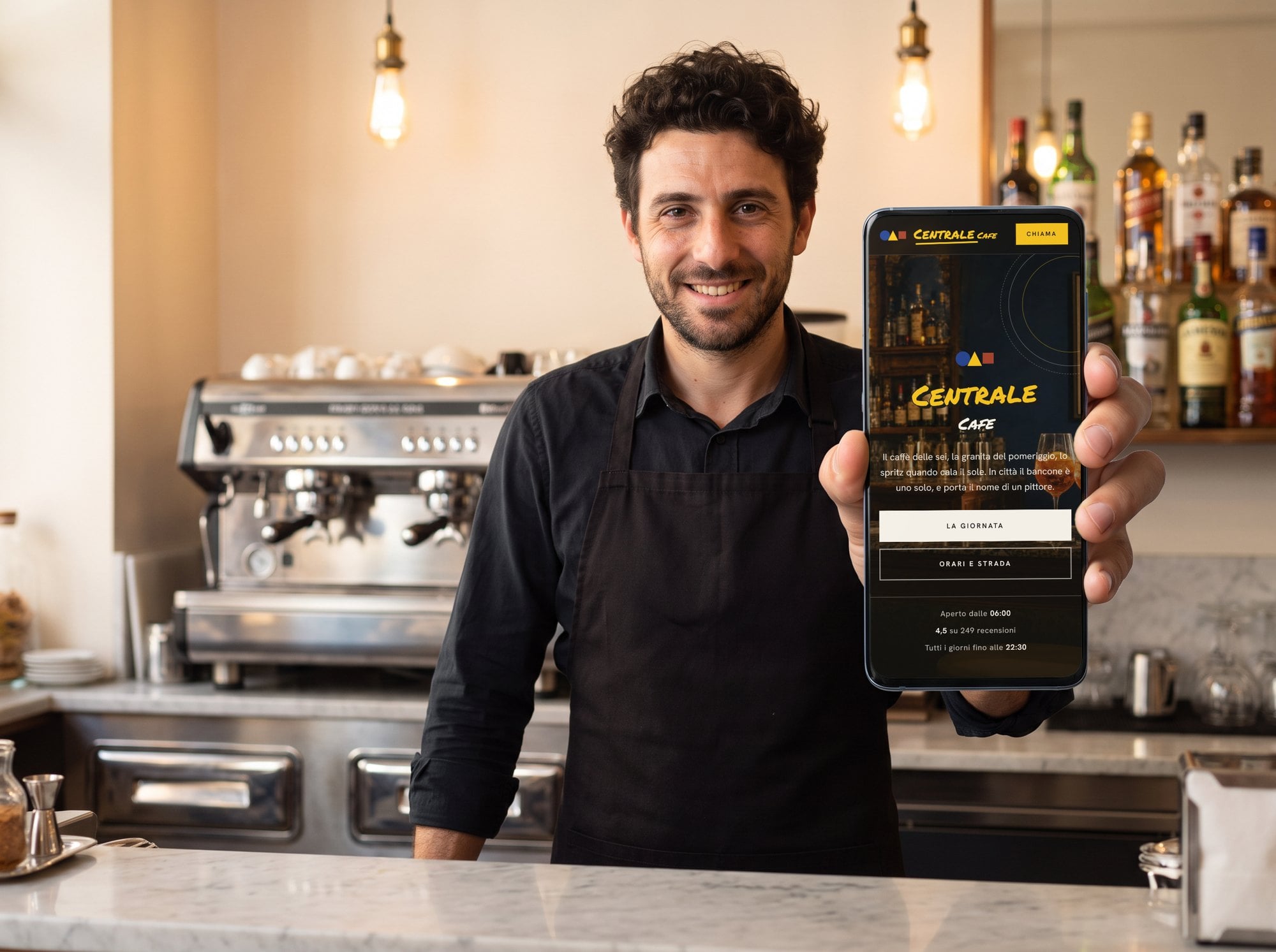 Il titolare di un bar mostra il sito del locale sul telefono
