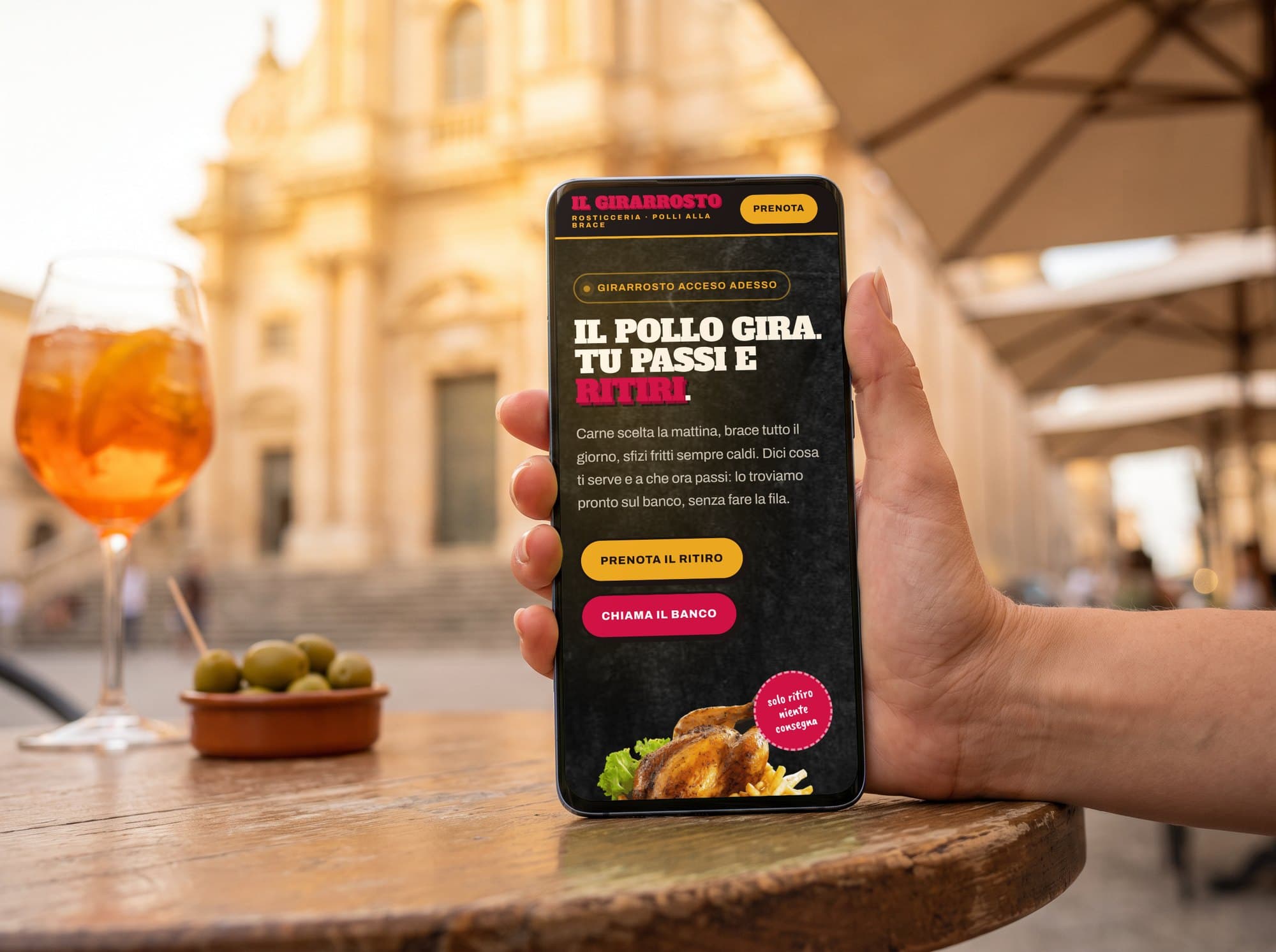 Una cliente apre dal telefono il sito di una rosticceria, seduta in piazza