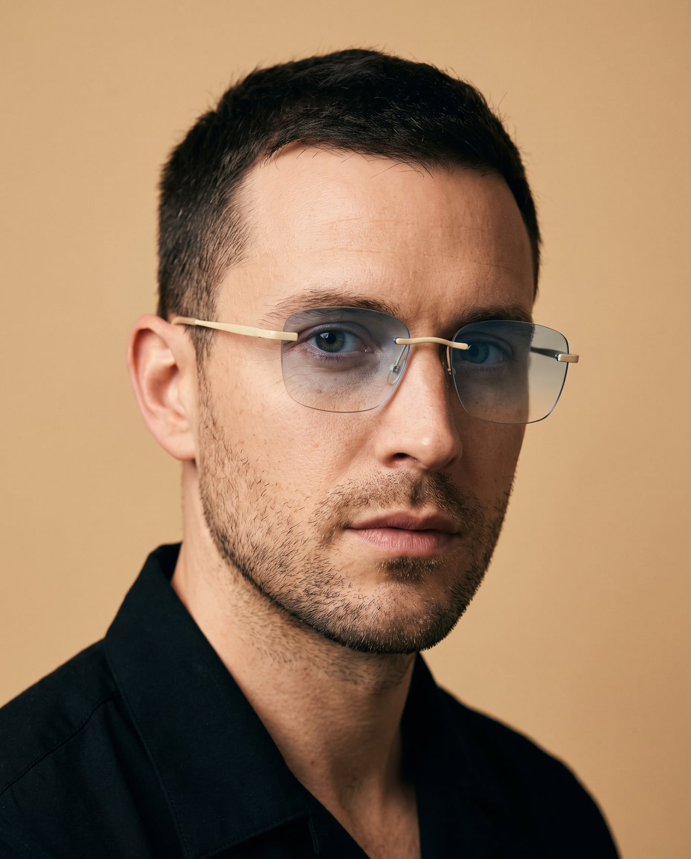 Uomo con occhiali da sole rimless in oro chiaro e lenti sfumate azzurre
